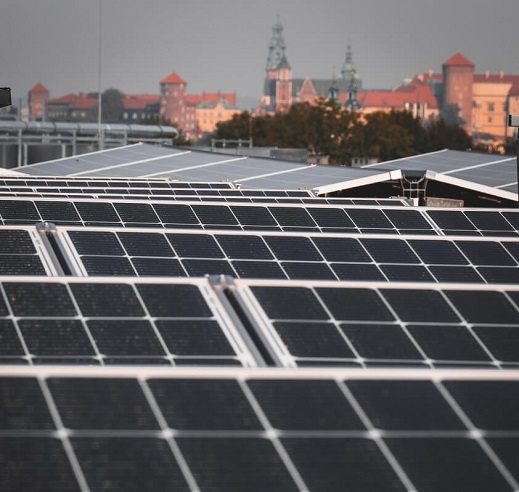 Widoczne panele fotowoltaiczne oświetlane przez promienie słoneczne.